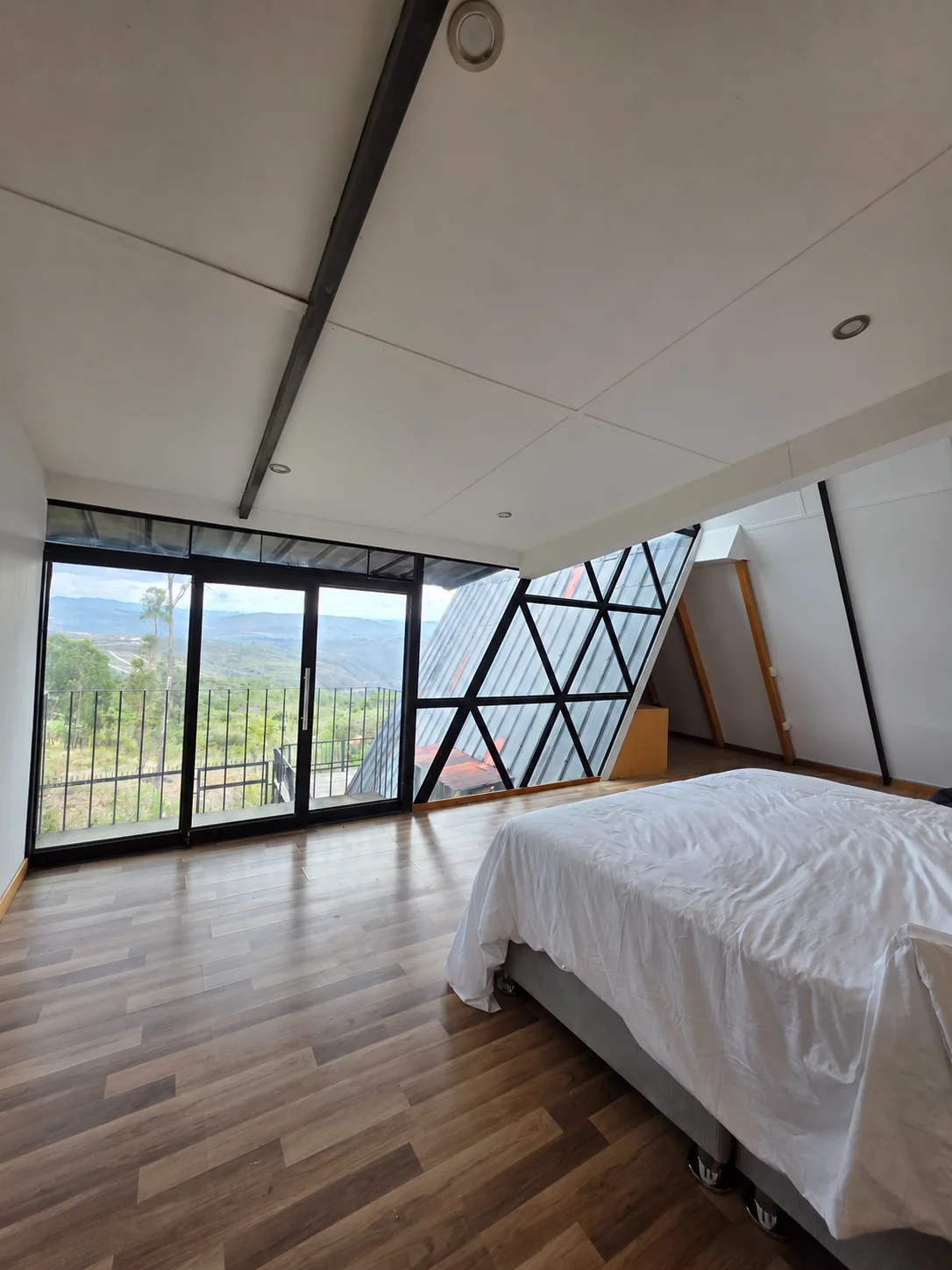 Habitación principal con cama King y ventanales hacia las montañas